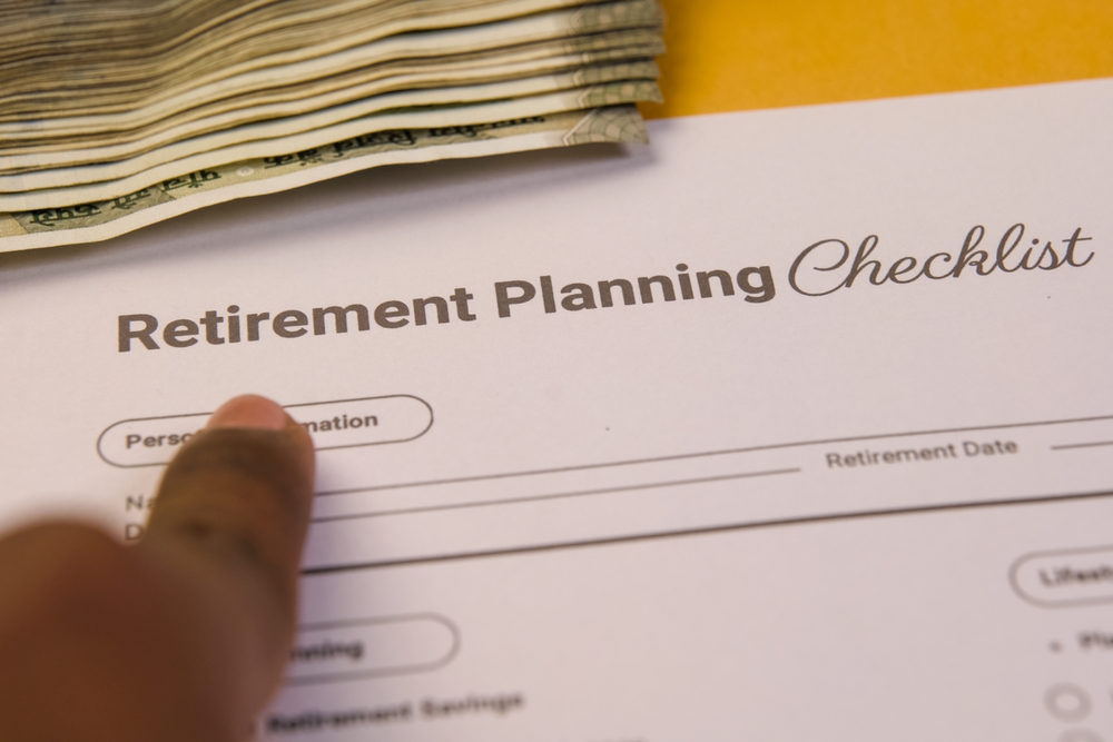 A,person,points,to,a,retirement,checklist,surrounded,by,money,