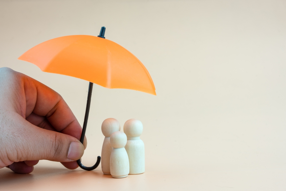 Insurance,concept.,wooden,family,peg,dolls,with,umbrella.,family,,life,